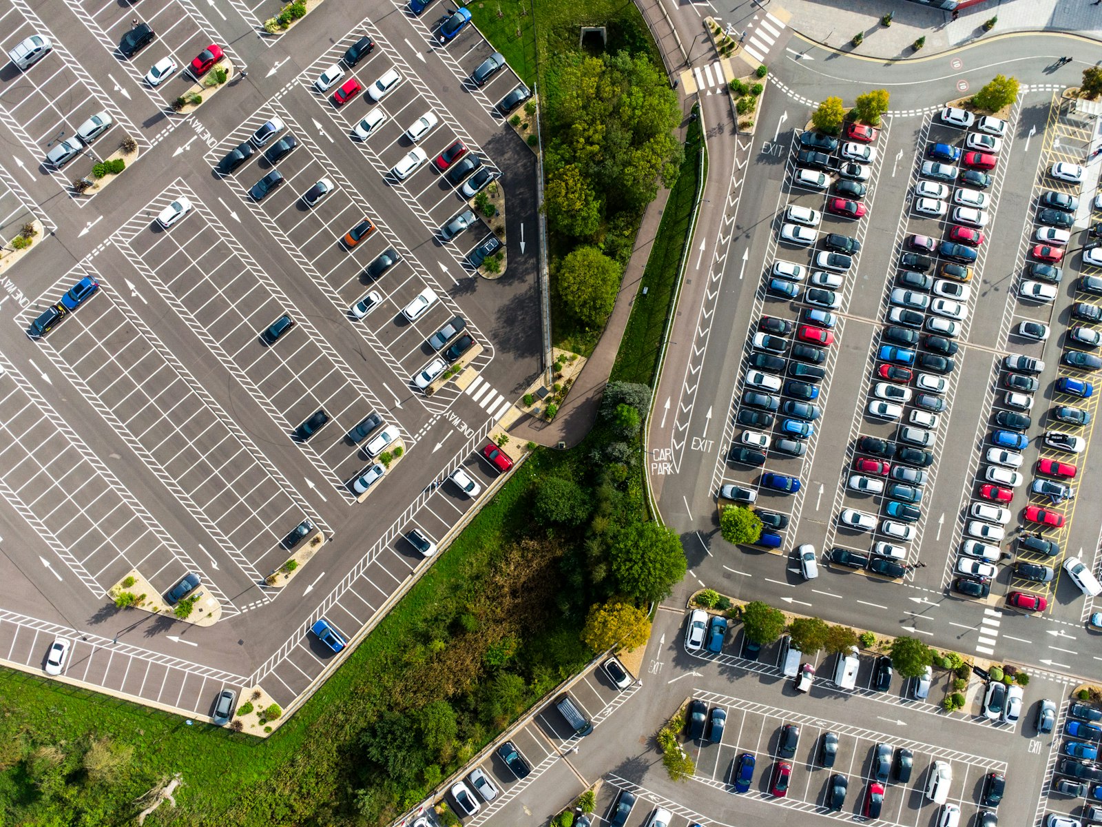aerial parking lot of vehicles representing rental versus used car ownership choices