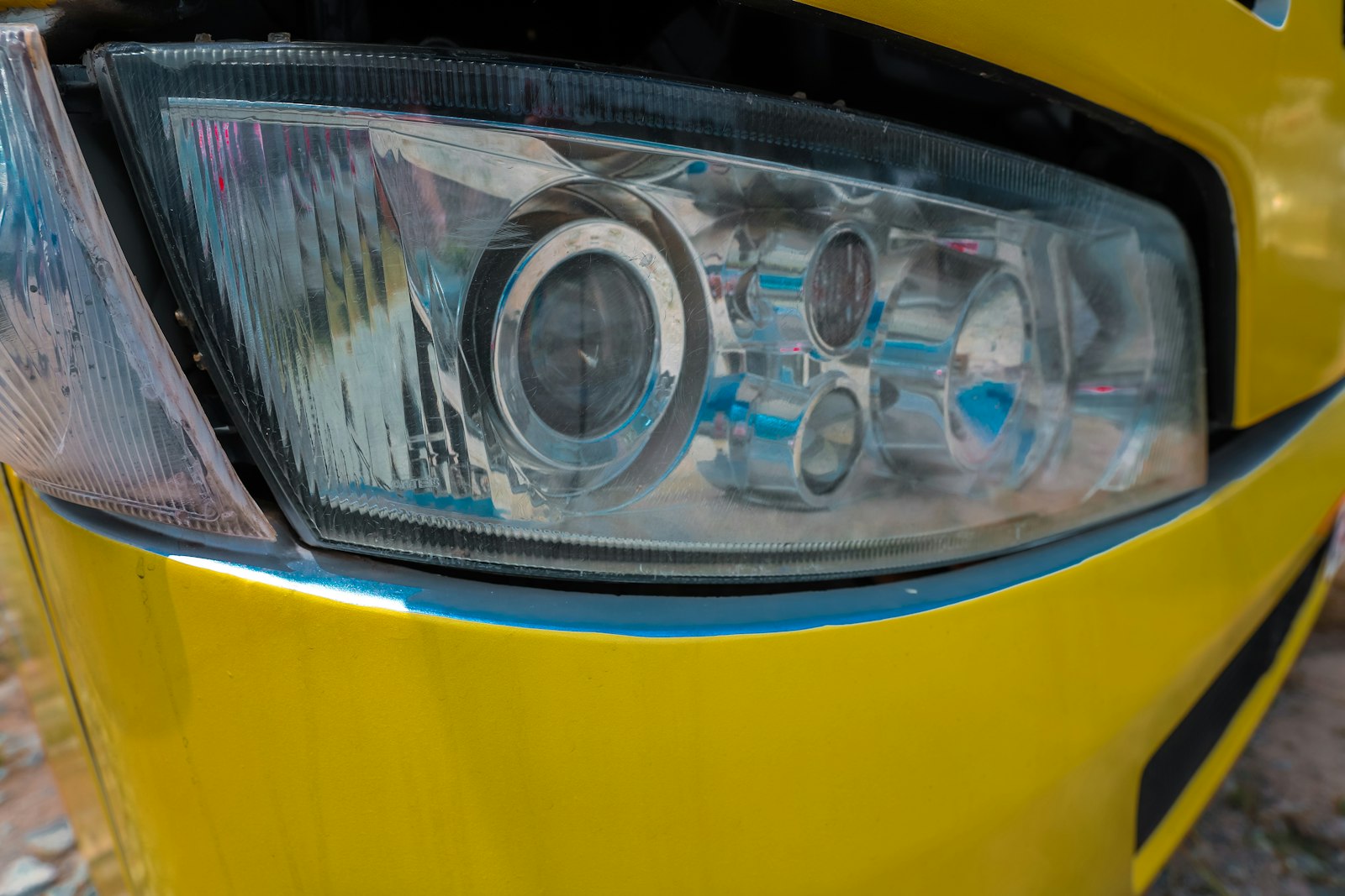 close-up vehicle headlight used to compare restoration versus replacement