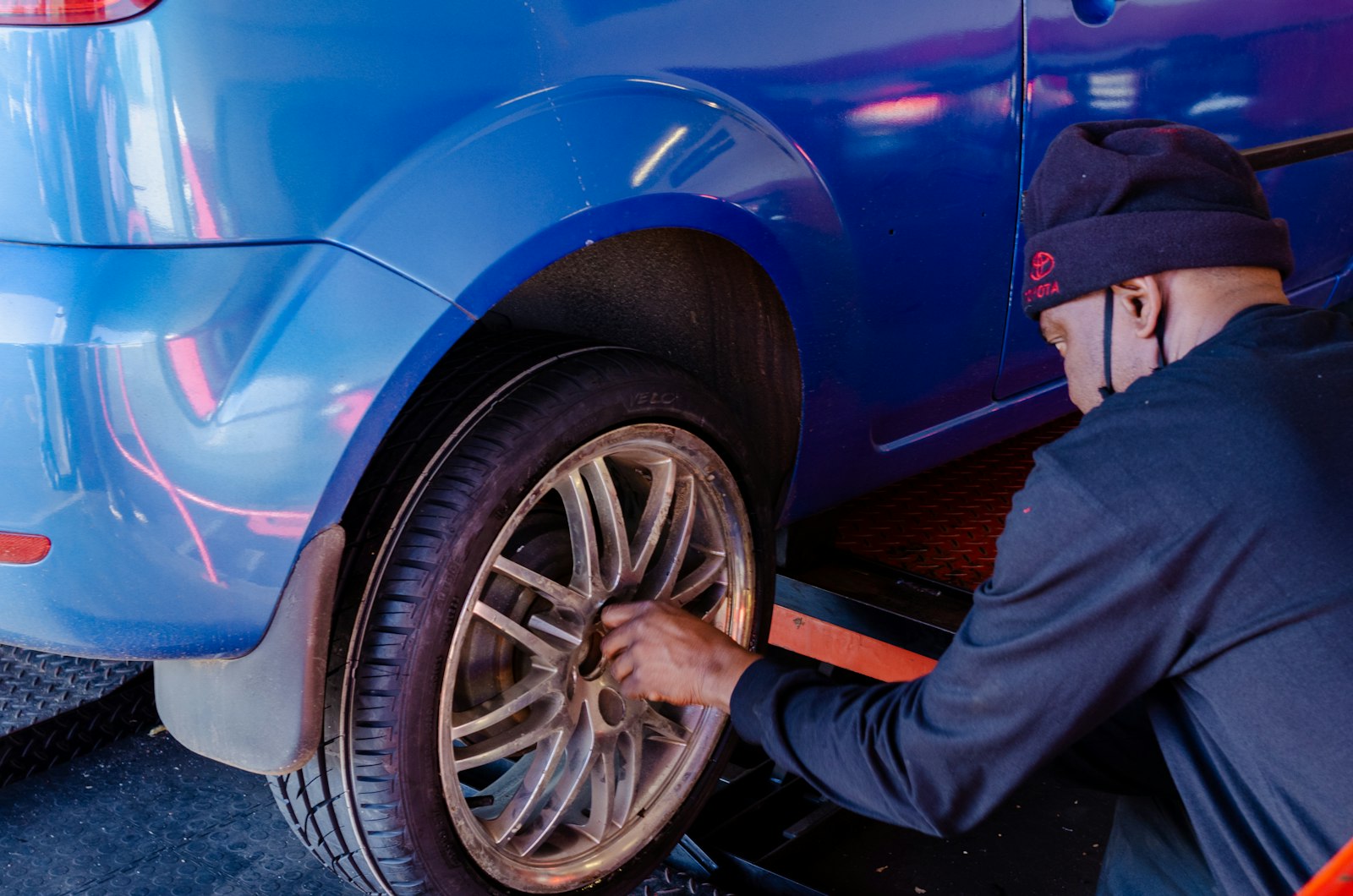 driver beside a car representing high-mileage wear from rideshare work