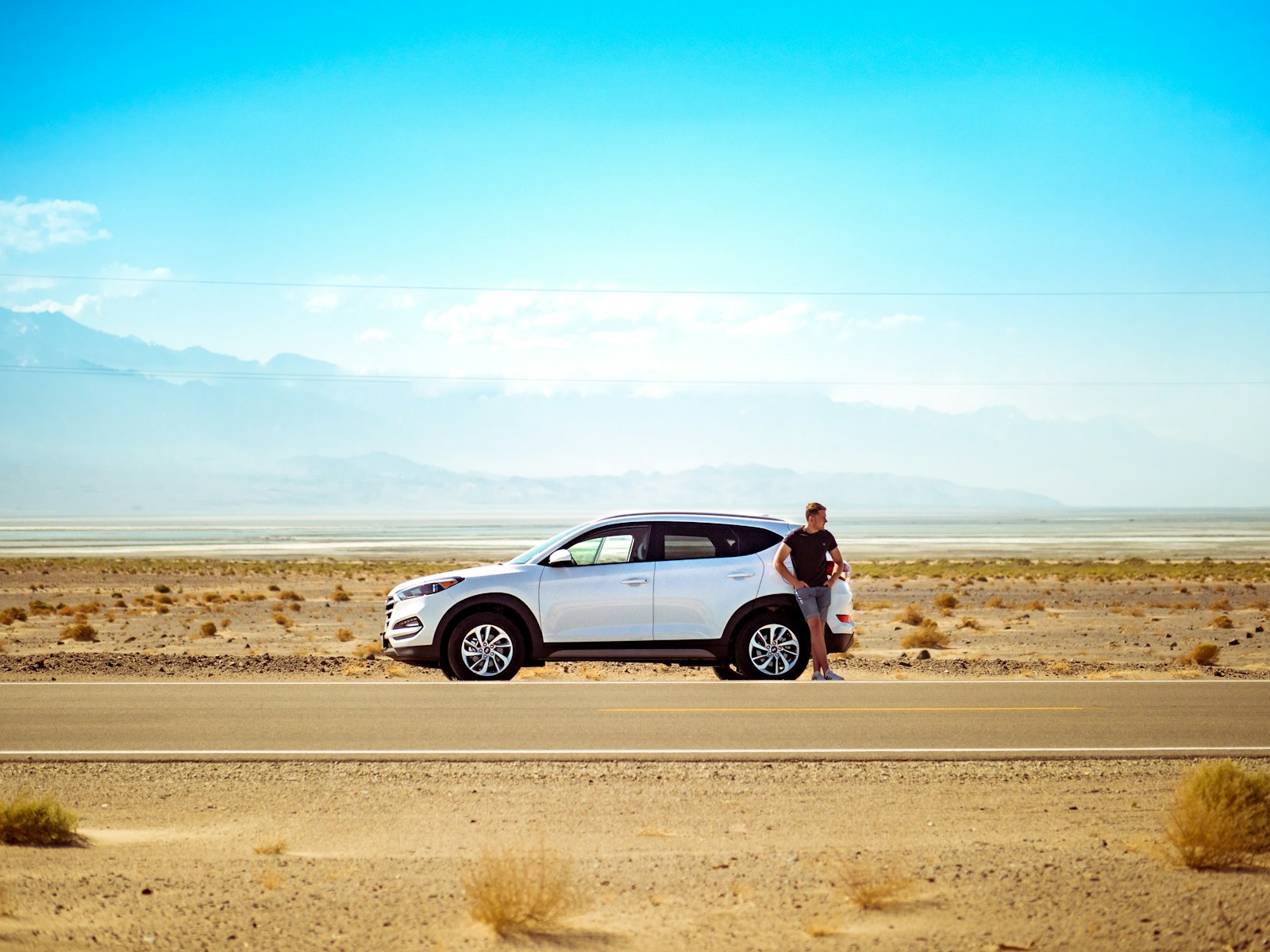 driver beside a vehicle representing weekly gig car rental budgeting