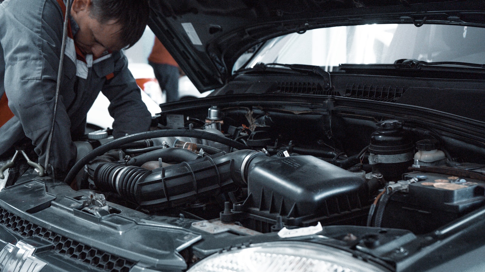mechanic inspecting a car engine during high-mileage maintenance