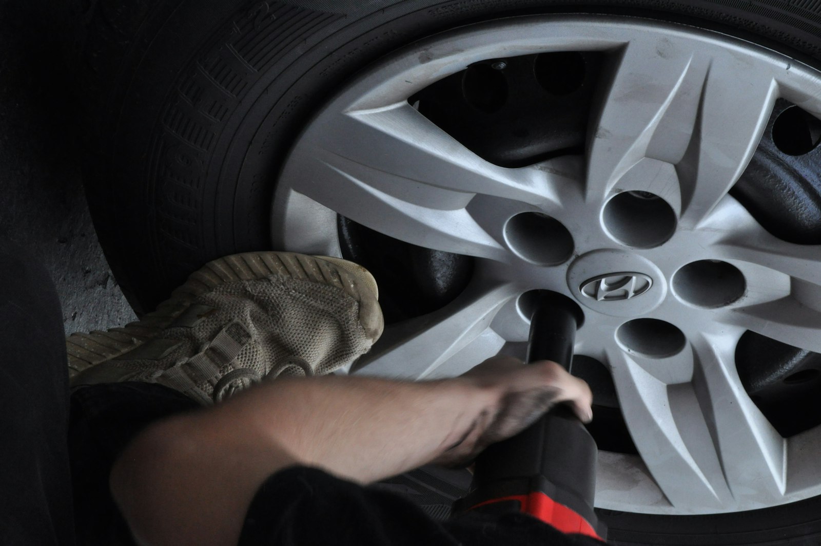 person changing a tire on a high-mileage work vehicle